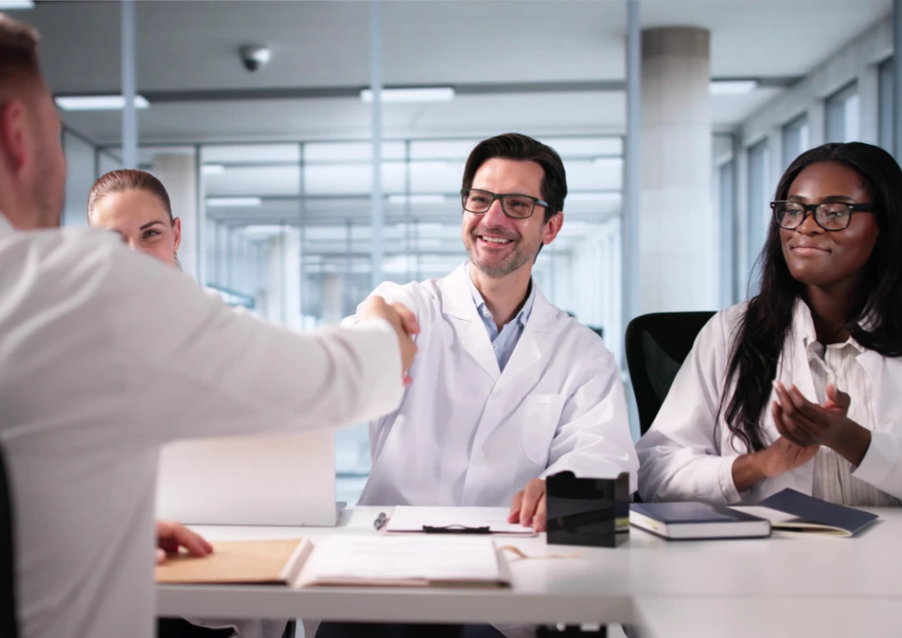 pharmacy business owner shaking hands with advisor